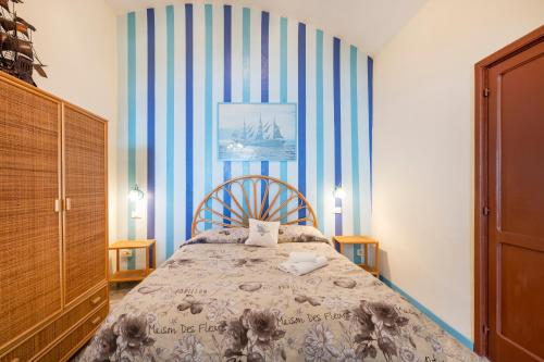 a bedroom with a bed with a striped wall at Torre Turbolo Apartments in Massa Lubrense
