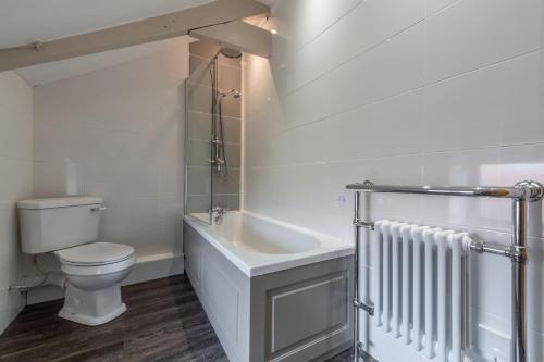 Baño blanco con aseo y lavamanos en Greyhound Cottage, en Sculthorpe