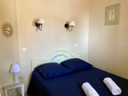 a bedroom with a blue bed with two pillows at Les Restanques rez jardin 2063 in Grimaud