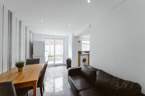 a living room with a table and a couch at Great Rooms in Stepney Green Station - 12 in London