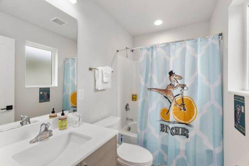 a bathroom with a shower curtain with a woman on a bike at Evan's sweet suite - Micro Studio - 91Walkscore in Seattle