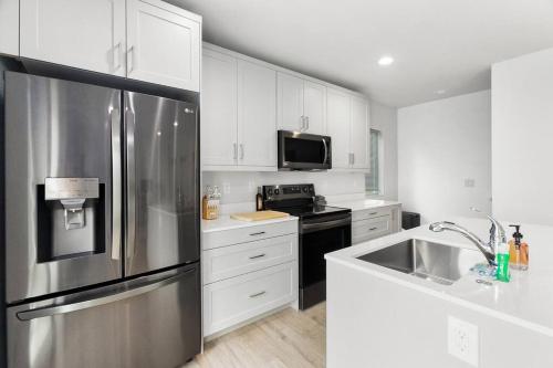 uma cozinha com um frigorífico de aço inoxidável e um lavatório em Evan's sweet suite - Micro Studio - 91Walkscore em Seattle