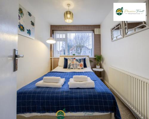 um quarto com uma cama azul com duas almofadas em 3BR House with Garden Very Close To Coventry Building Society Arena aka Ricoh Arena w Free Parking and FREE Wifi - RRN em Exhall