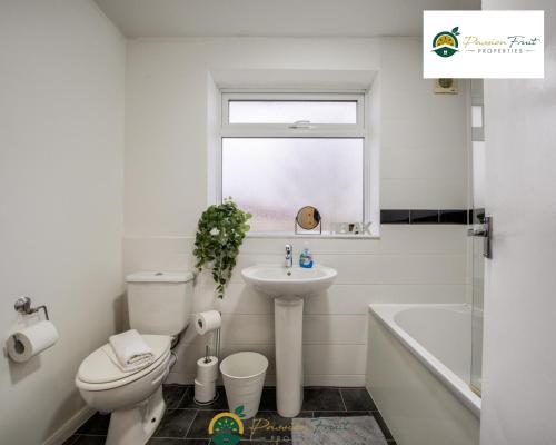 een witte badkamer met een toilet en een wastafel bij 3BR House with Garden Very Close To Coventry Building Society Arena aka Ricoh Arena w Free Parking and FREE Wifi - RRN in Exhall