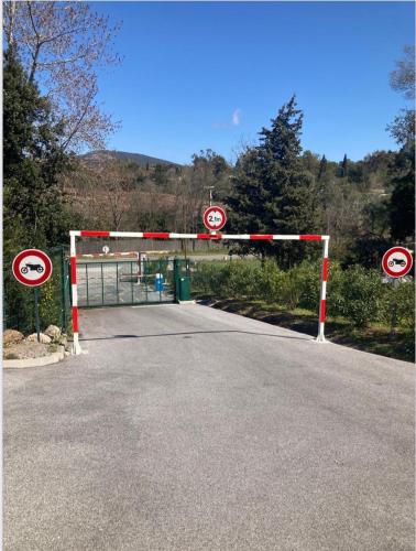 a gate on a road with street signs at Les Restanques rez jardin 2063 in Grimaud