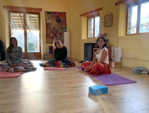 tres mujeres sentadas en el suelo en una clase de yoga en Casa Rural Petricor, Ordesa, en Vío