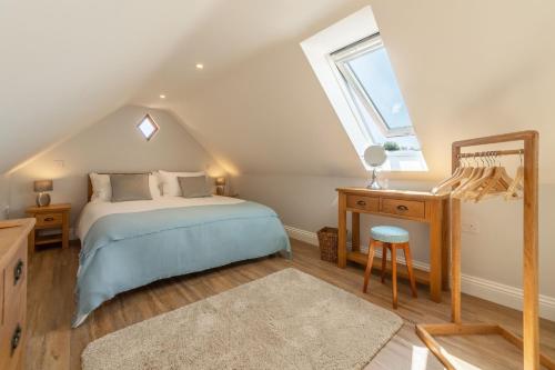 a bedroom with a bed and a desk and a window at Tudor Rose in Aylsham