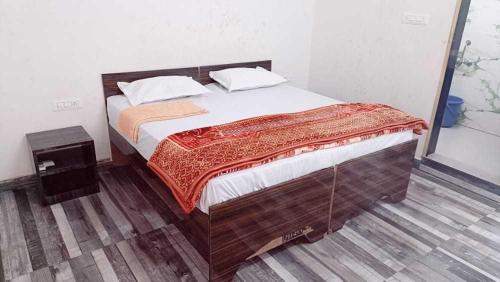 1 dormitorio con 1 cama grande con marco de madera en OYO The Moonshine Hotel, en Charkhi Dādri