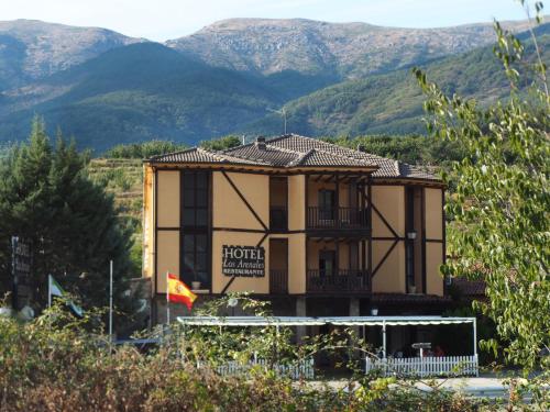 a building with a balcony and mountains in the background at HOTEL LOS ARENALES DE JERTE in Jerte