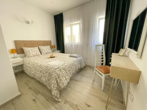 een kleine slaapkamer met een bed en een tafel bij Our Charming House in Portimão