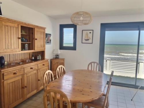 une salle à manger avec une table et une vue sur l'océan dans l'établissement Villa de la plage, front de mer, Juno beach, à Bernières-sur-Mer