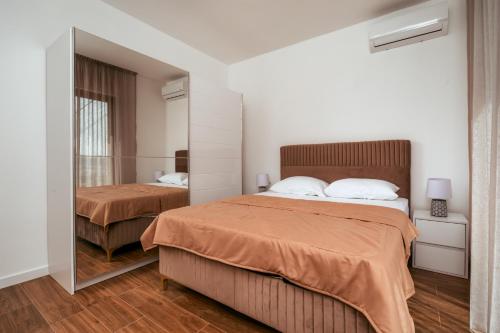 a bedroom with two beds and a mirror at Uphill Glavanovic Villas in Bar