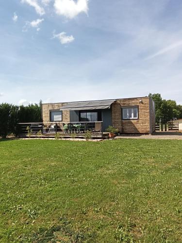 uma pequena casa com um campo de relva em frente em Chalet Miquéou Gers em Marseillan