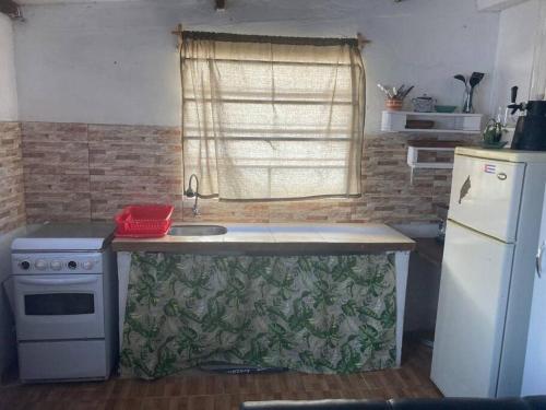 eine kleine Küche mit Spüle und Kühlschrank in der Unterkunft Depto a 6 cuadras de la playa y 5 min. casco histórico in Colonia del Sacramento
