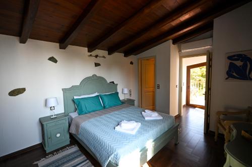 a bedroom with a large bed with blue pillows at Villa Krio Pigadi in Kechria