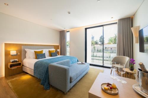 a hotel room with a bed and a chair at Martinhal Lisbon Oriente in Lisbon