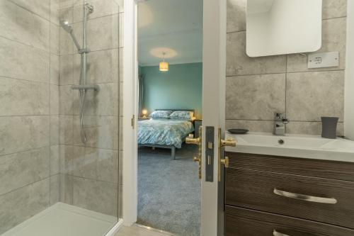 łazienka z prysznicem, umywalką i łóżkiem w obiekcie Heacham Hidey Hole w mieście Heacham