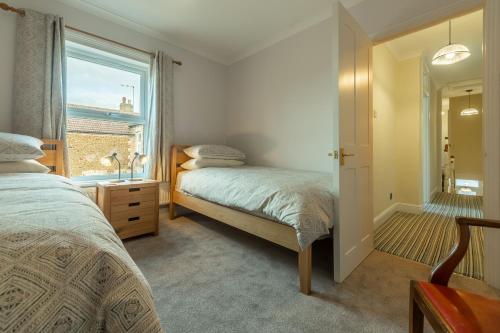 1 dormitorio con 2 camas y ventana en Heacham Hidey Hole en Heacham