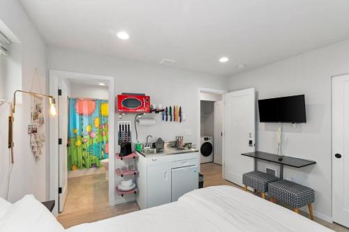 a white room with a bedroom with a bed and a kitchen at Mae's sweet suite - Micro Studio - 91Walkscore in Seattle