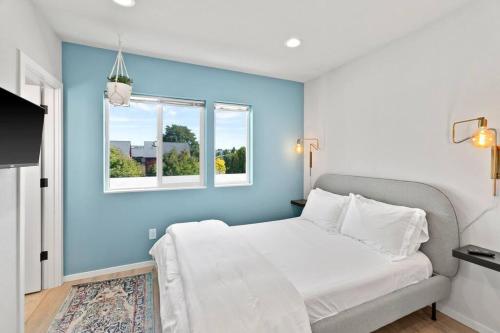 una camera blu con un letto e una finestra di Mae's sweet suite - Micro Studio - 91Walkscore a Seattle