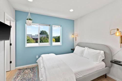 a blue bedroom with a bed and a window at Mae's sweet suite - Micro Studio - 91Walkscore in Seattle