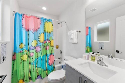 a bathroom with a shower curtain with a toilet and a sink at Mae's sweet suite - Micro Studio - 91Walkscore in Seattle