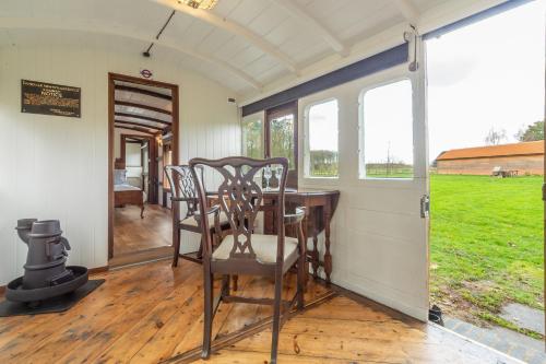 a dining room with a table and chairs at The Railway Carriage in Melton Constable