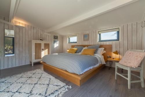 a bedroom with a large bed and a chair at The Lavender Shack in Brooke