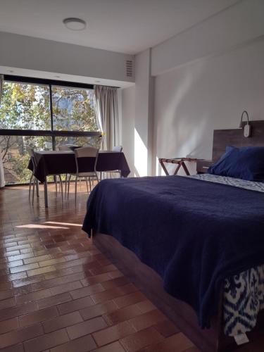 a bedroom with a bed and a table and chairs at Luminoso Ambiente, con cochera en lo mejor de La Perla in Mar del Plata