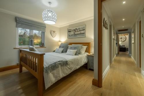 a bedroom with a large bed and a hallway at Willow Lodge in Holme next the Sea