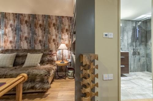 a living room with a couch and a shower at The Bothy in Ringstead