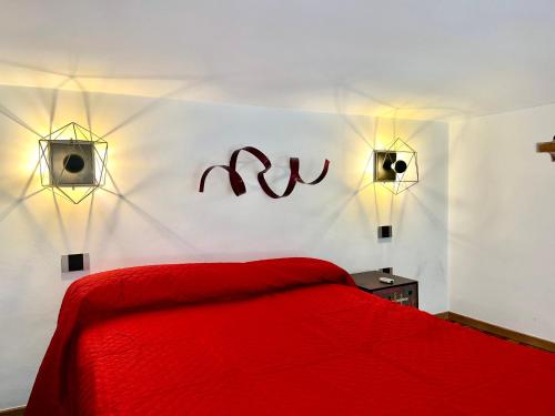 a bedroom with a red bed and two lights on the wall at [Loft in centro] Boutique 65 in Turin