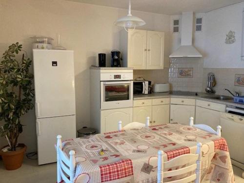 kuchnia ze stołem i białą lodówką w obiekcie Studio tout équipé avec loggia, parking et Wi-Fi à 50m des cures - 2 pers - Animaux OK - FR-1-703-22 w mieście Amélie-les-Bains-Palalda