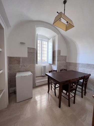 Un comedor con mesa y sillas y una ventana. en B&B ARCHÈO, en Andria