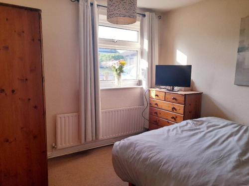 a bedroom with a bed and a window with a television at Spacious Bungalow in Pinxton