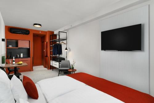 - une chambre avec un lit et une télévision murale dans l'établissement Florin Apart Hotel, à Budapest