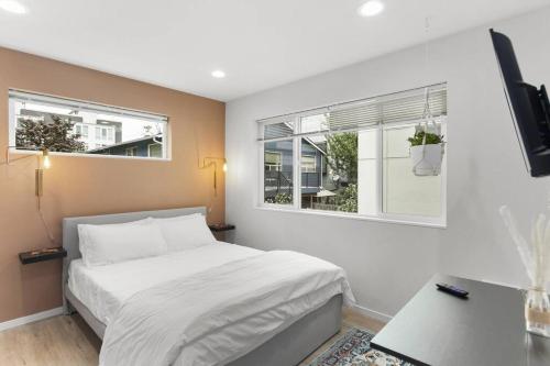 a bedroom with a white bed and two windows at Chase's sweet suite - Micro Studio - 91Walkscore in Seattle