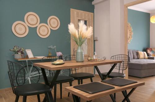 a living room with a table with chairs and hats on the wall at Sitia Cozy Apartment in Sitia