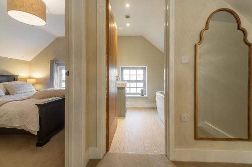 a bedroom with a bed and a mirror at Foxhill House in South Creake