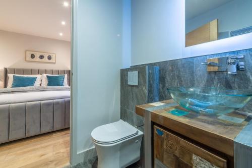 ein Bad mit einem Glaswaschbecken und einem Bett in der Unterkunft Spindrift 4 in Hunstanton