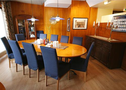 a dining room with a wooden table and blue chairs at Hotel Savoy in Mariehamn