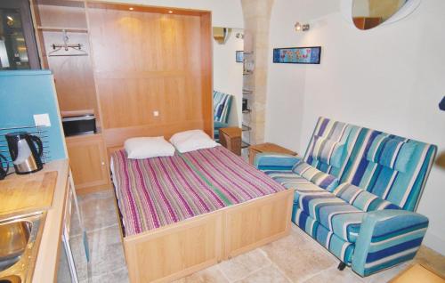 ボーケールにあるNice Apartment In Beaucaire With Wifiのベッドと椅子付きの小さな部屋です。