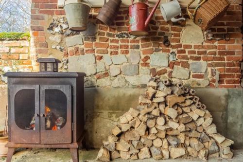 a pile of fire wood next to a brick wall at Able Stables in East Rudham