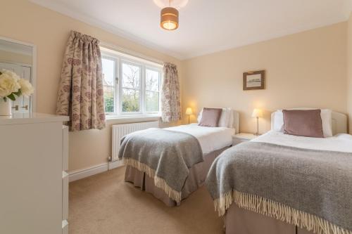 a bedroom with two beds and a window at Arisaig in Wells next the Sea