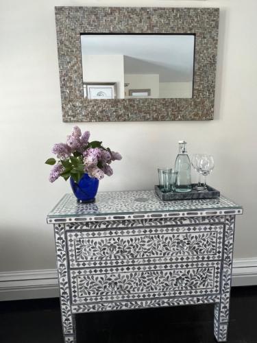 a mirror on top of a dresser with flowers on it at The Platinum Pebble Boutique Inn - Adults Only Property in Harwich Port