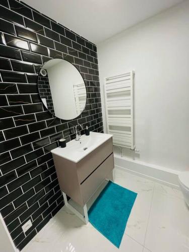 une salle de bain avec un lavabo et un miroir dans l'établissement Appartement Premium 4 Stars - Antigone, à Montpellier