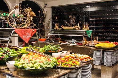 a buffet with many plates of food on a table at Serrambi Resort in Porto De Galinhas