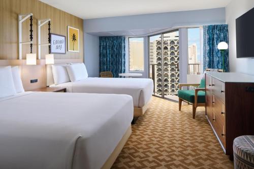 a hotel room with two beds and a window at Waikiki Malia in Honolulu