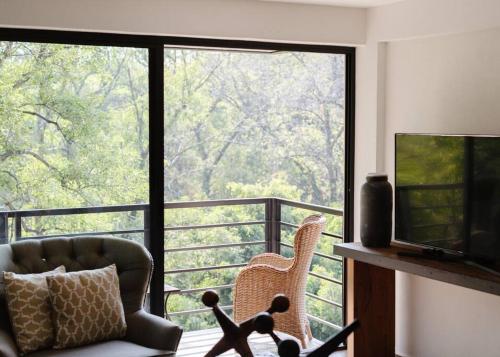 a living room with a couch and a large window at Mr. W Park View Balcony Espana 602 in Mexico City