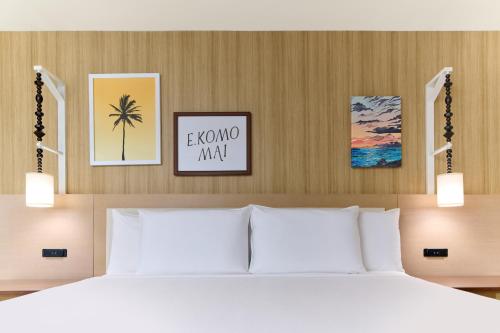 a bedroom with a bed and pictures on the wall at Waikiki Malia in Honolulu